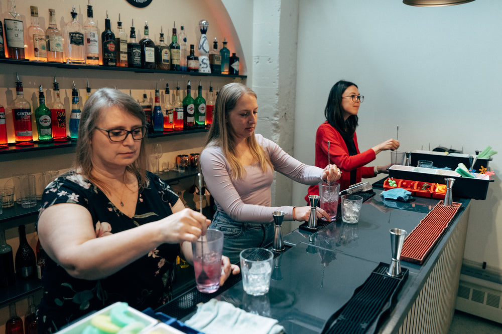 Students building cocktails behind the 22-foot bar at Fine Art Bartending School, where Maple Ridge students train