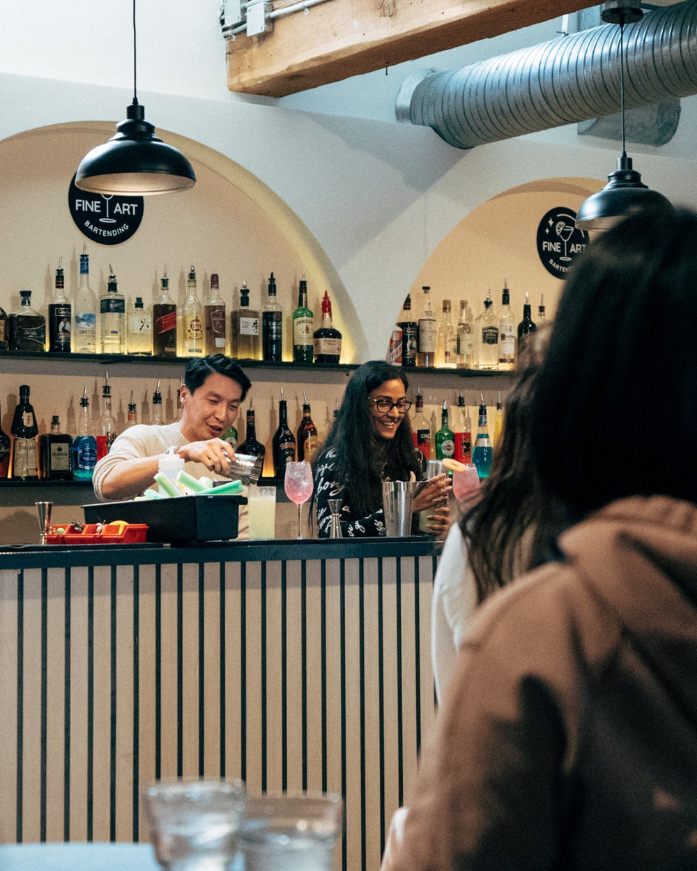 A guest mixing cocktails at a company holiday party behind Fine Art Bartending's Gastown bar