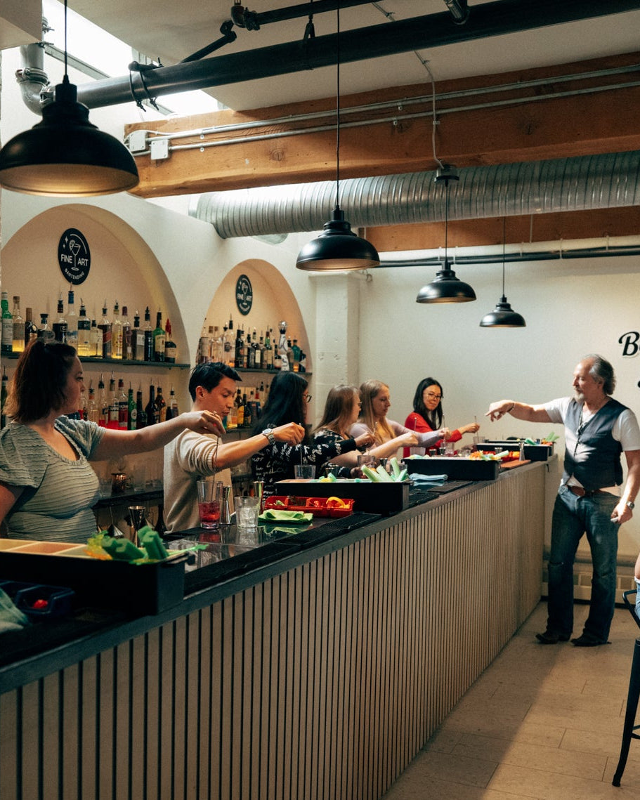 A guest pouring a cocktail behind the Fine Art bar