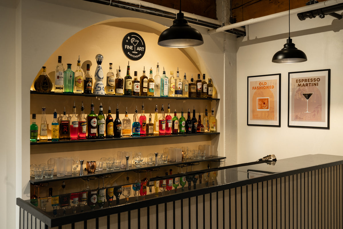 Modern fine art bartending school bar interior with tables, chairs, and shelves displaying bottles