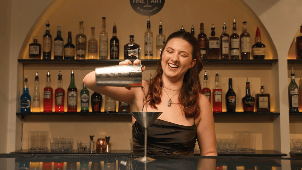 A guest pouring a cocktail behind the Fine Art bar