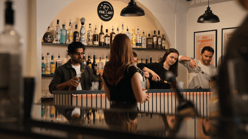 A guest pouring a cocktail behind the Fine Art bar