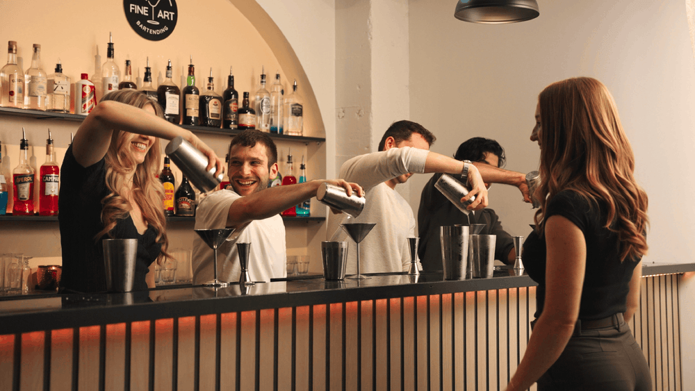 Students shaking cocktails behind the 22-foot bar at Fine Art Bartending School, where Port Coquitlam students train