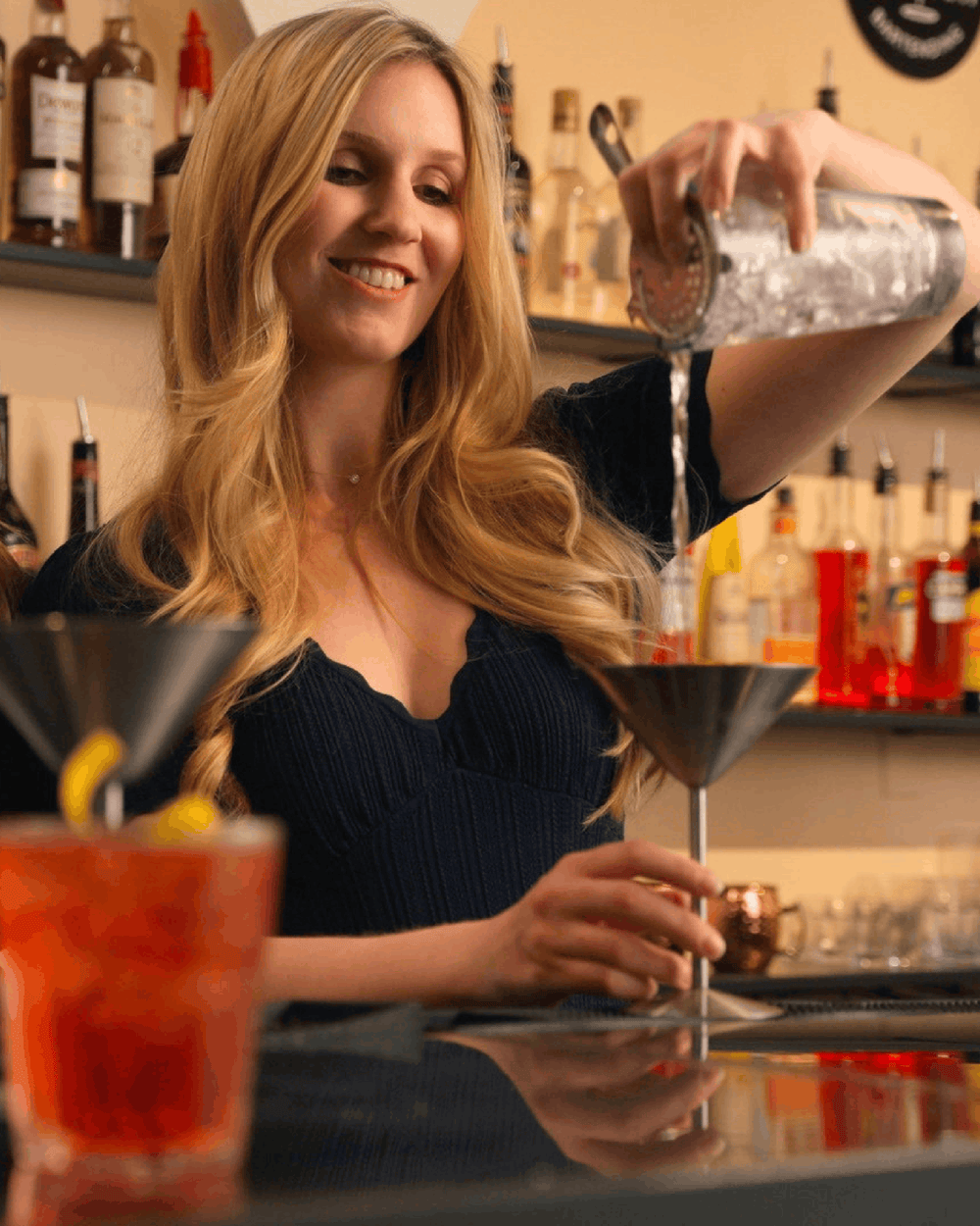 A guest pouring a cocktail behind the Fine Art bar