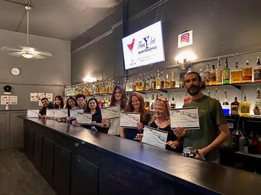 Students holding their certificates in the classroom at the Fine Art Bartending School near Delta, British Columbia