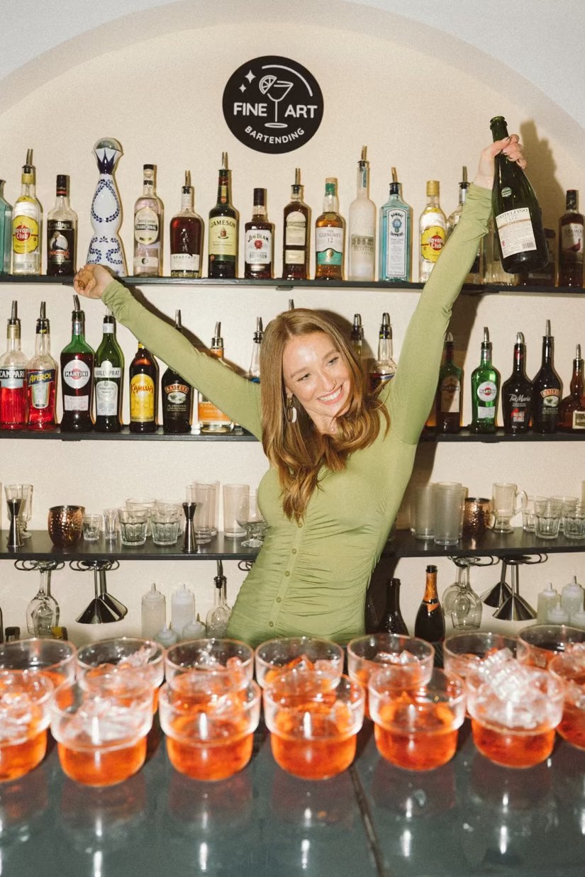 A guest pouring a cocktail behind the Fine Art bar
